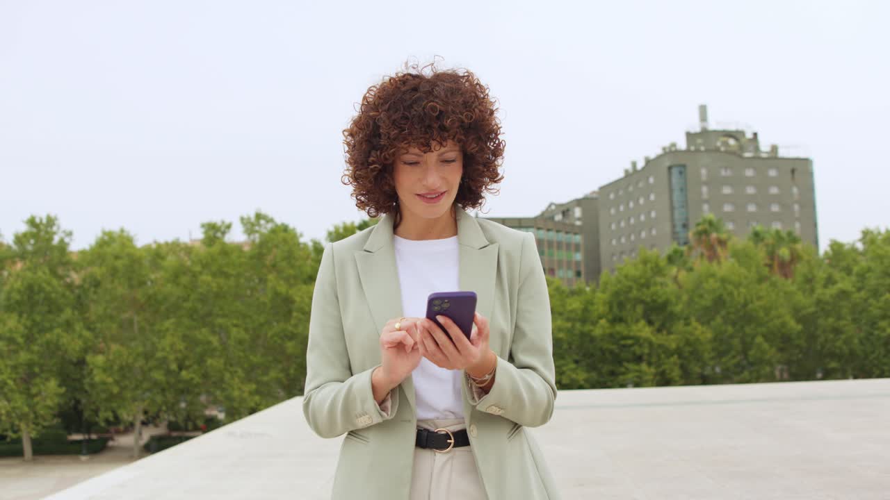 Donna con i capelli ricci che usa il cellulare