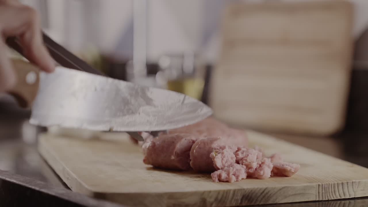 Hands Cutting Sausage on a Wooden Board