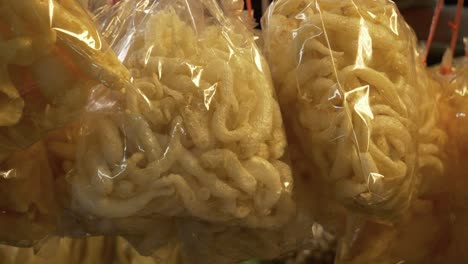 deep fried pork skin in plastic bag at street food market for sale documentary