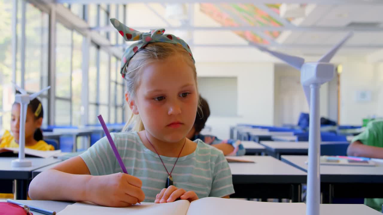 Studentessa caucasica con quaderno al banco in classe 4k