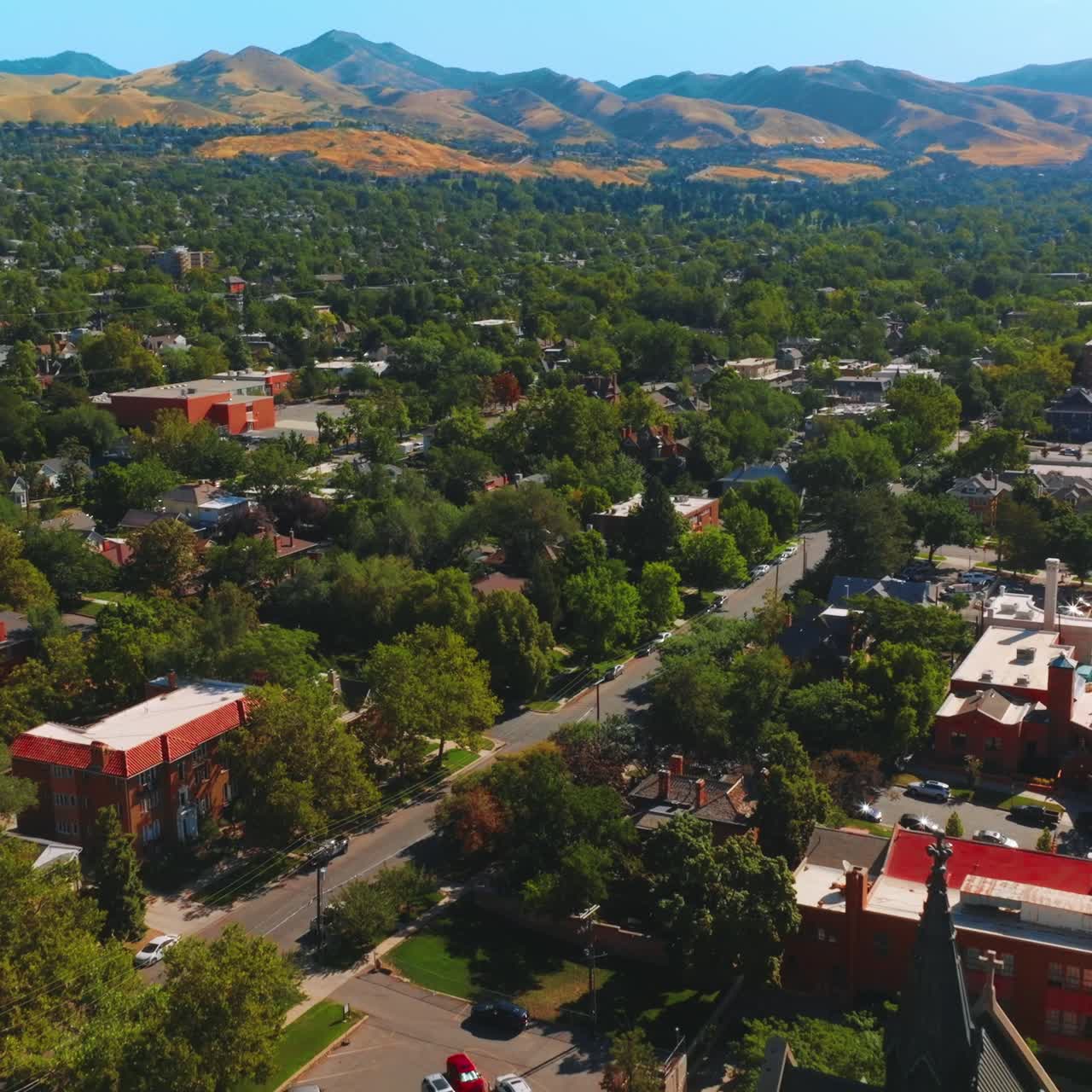 Amazing green city with gorgeous cathedral. Sunny view of Salt Lake City, Utah, United States at backdrop of beautiful mountains