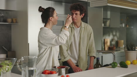 a couple cooking and interacting together in a modern kitchen