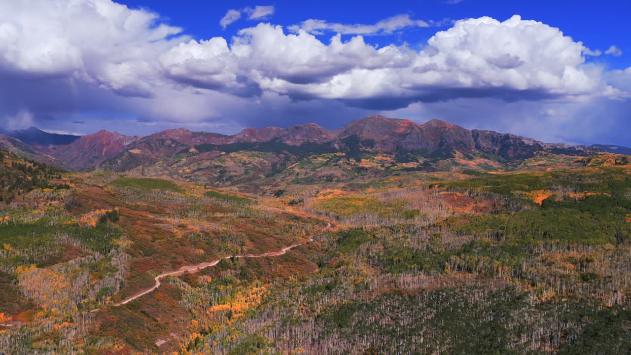 Kebler Pass Ruby Afley Ruby Peak Lake Irwin Paonia Somerset Crested Butte Colorado luftfoto drone solrig eftermiddag efterår mørke skyer blå himmel farverige gyldne Aspen Trees grusvej baglæns panorering op