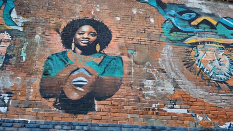 graffiti mural of a woman on a brick wall