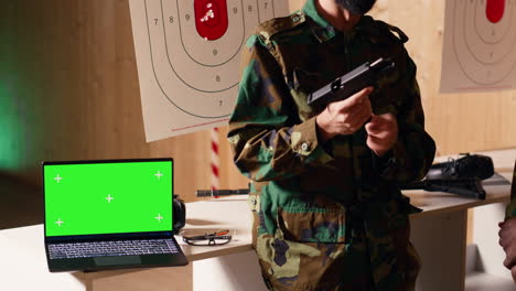 mockup laptop next to soldiers in shooting range training with weapons