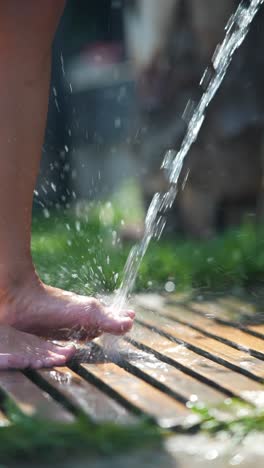 child washing their feet outside