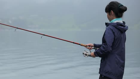 Woman-fishing-on-Fishing-rod-spinning-in-Norway.