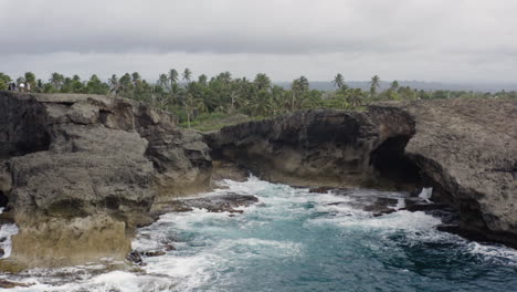 Espumosas-Olas-Del-Océano-Rompiendo-Sobre-Acantilados-Rocosos-En-La-Cueva-Del-Indio-En-Las-Piedras,-Puerto-Rico---Toma-Aérea-De-Drones