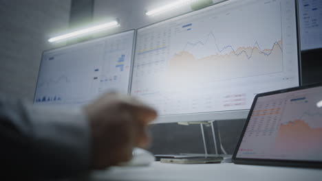 stock exchange broker monitoring real-time stocks, exchange market charts on computer with multi-monitor desktop setup, talking on phone. african american investment agent in office. vertical shot.