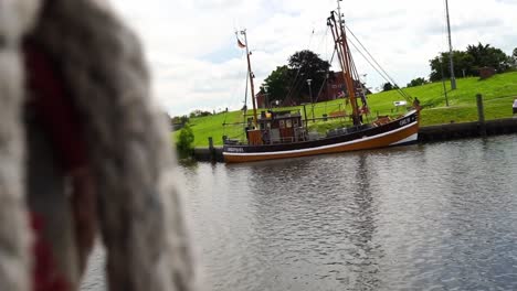 Ein-Dickes-Seil-Hängt-An-Einem-Steinpoller-In-Einem-Hafen-In-Der-Stadt-Norden-In-Deutschland