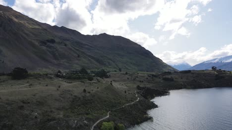 Toma-Cinematográfica-Del-Lago-Wanaka,-La-Joya-Alpina-Más-Cautivadora-Y-Encantadora-Rodeada-De-Majestuosas-Montañas-Cubiertas-De-Nieve.