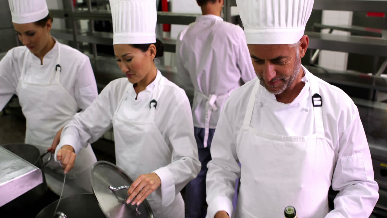 chef freyendo verduras y añadiendo aceite de oliva a la sartén