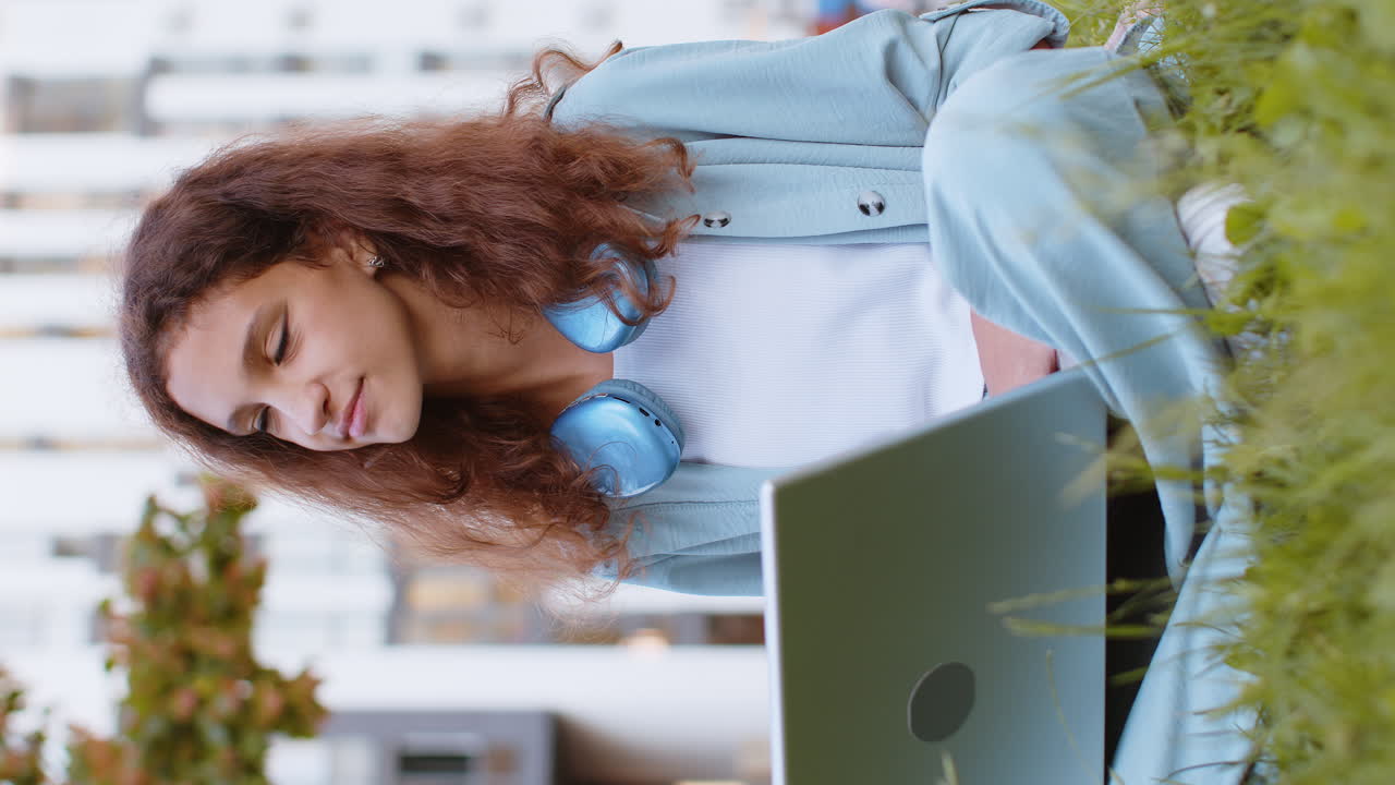 Preteen child girl freelancer closing laptop pc after finishing work sitting on grass in city park