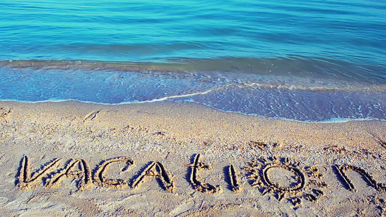 The inscription Vacation on sand. Inscription on sand