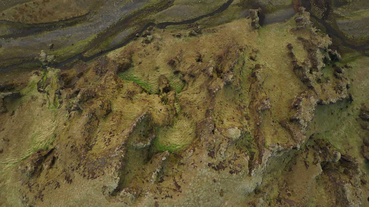 Aerial view of rugged, moss-covered ridges and valleys in northern Iceland, highlighting the region's unique volcanic terrain and untouched wilderness.