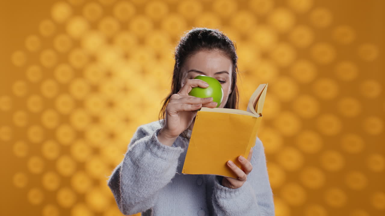 mujer leyendo un libro y disfrutando de una manzana fresca, viviendo saludable, fondo de estudio