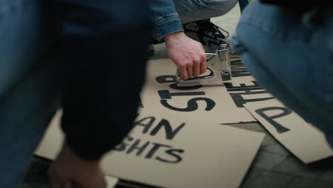 caucasian man preparing cardboard banners for manifest against ukrainian war.