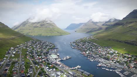 una impresionante vista aérea de klaksvik, islas feroe, con un tranquilo puerto rodeado de escarpadas y exuberantes montañas verdes, con una red de carreteras y casas encantadoras que salpican el paisaje
