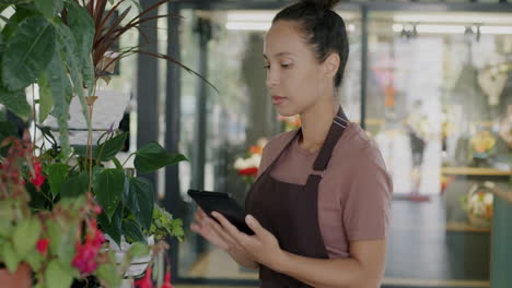 woman florist using tablet in plant shop