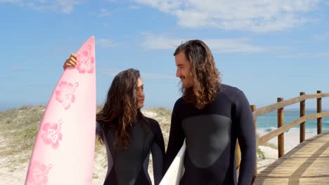 surfer couple with surfboard looking each other 4k