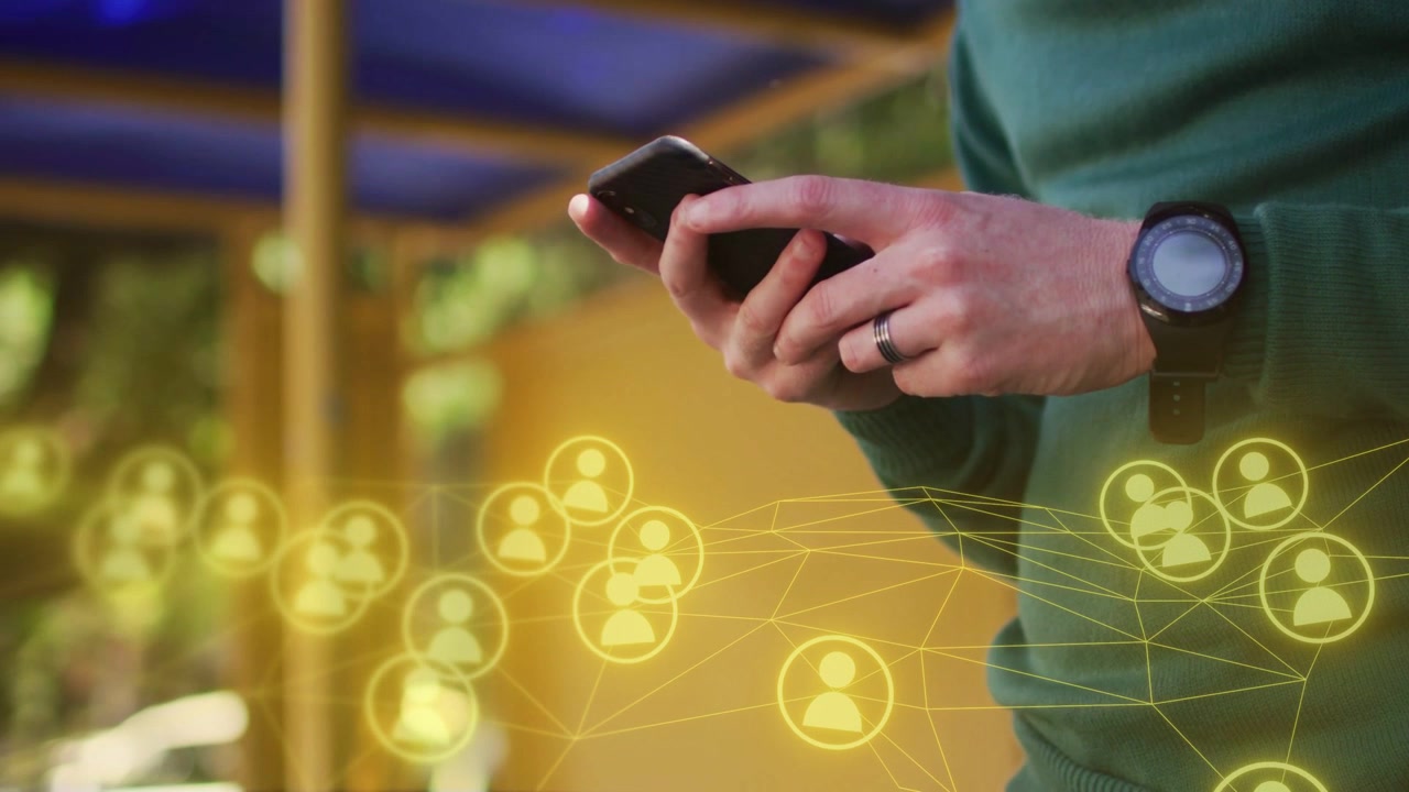 Uomo che tiene il telefono sul patio, che tocca con il pollice e anima nodi gialli sul telefono, navigando nel feed di rete