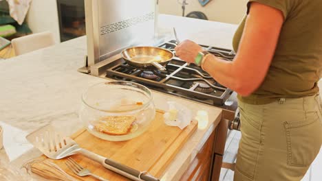a person preparing french toast in a kitchen