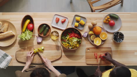 Vielfältiges-Paar-Kocht-Gemüsesalat-Am-Küchentisch