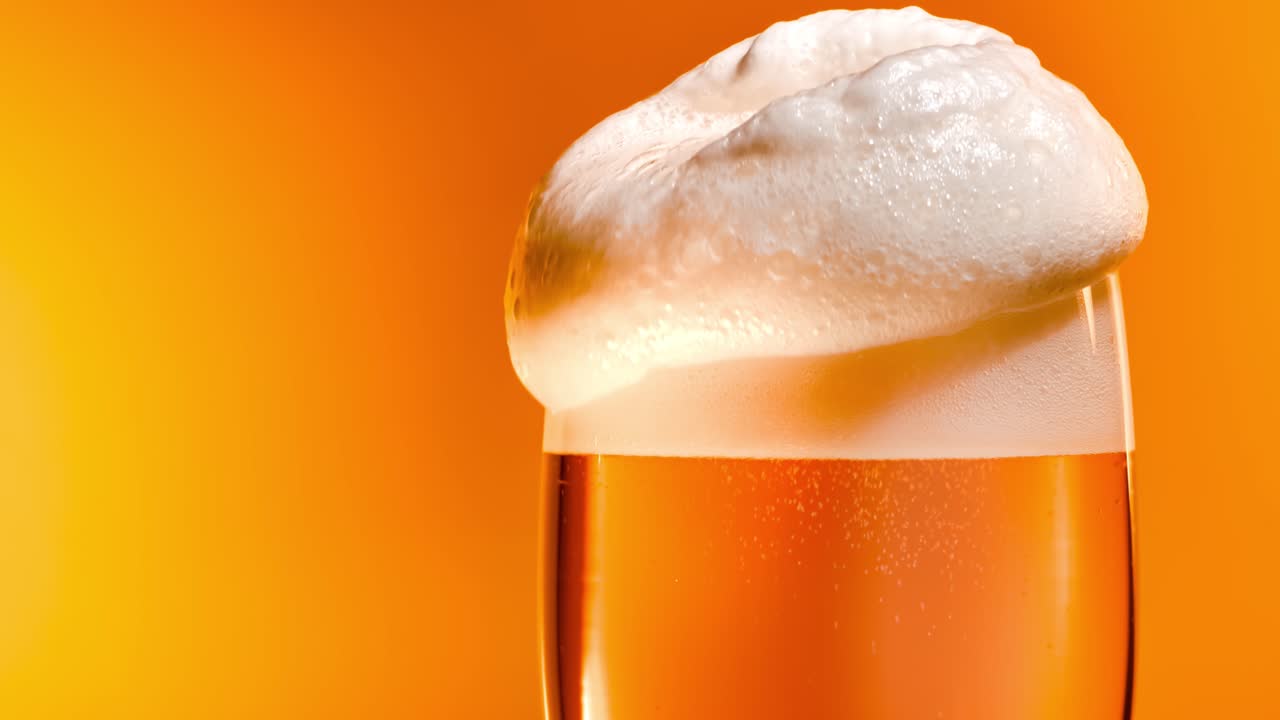 Lager beer settles in the glass with a white cap of foam