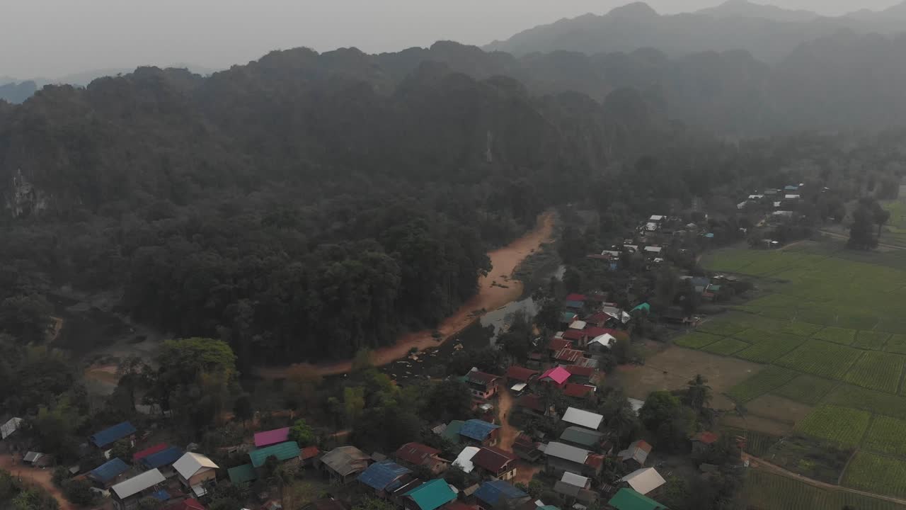 Vista da drone di un piccolo villaggio rurale vicino alla grotta di Kong Lor in una giornata nuvolosa, ripresa aerea.