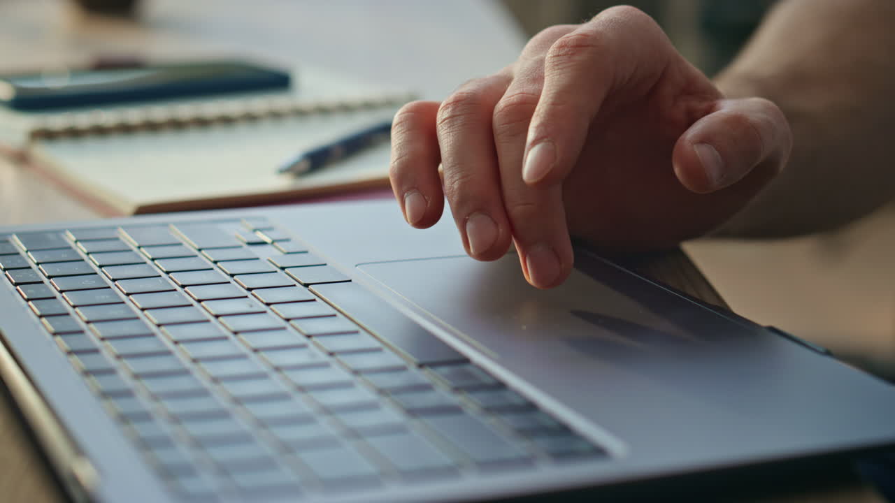 Freelancer scrolling touchpad laptop working online at remote workplace close up