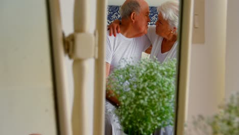 caucasian senior couple kissing each other in bedroom at comfortable home 4k