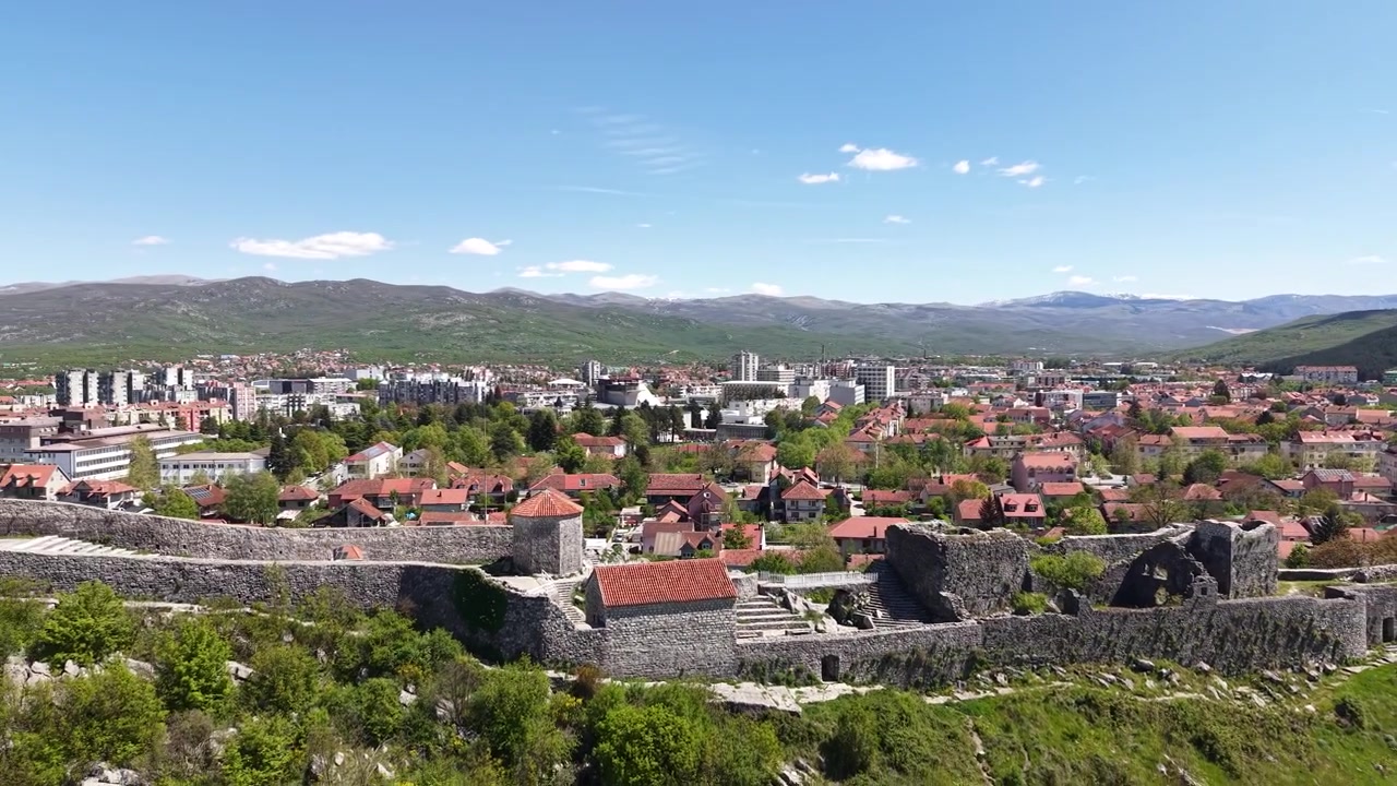 Nikšić, Černá Hora. Záběr dronem na středověké hradby pevnosti, známé jako Bedem, nad městem za slunečného dne.
