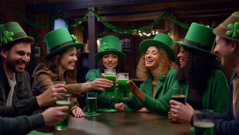 friends celebrating st. patrick's day with green beer and toasts at a bar