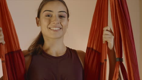 girl sitting in hammock for fly yoga at studio. woman swinging in yoga hammock