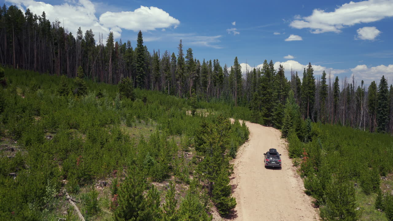 Mount of the Holy Cross Notch Mountain creek Falls Creek Trail Half moon pass AWD car driving dirt road car aerial drone Rocky Mountains Colorado Vail Minturn Red Cliff summer morning blue sky follow