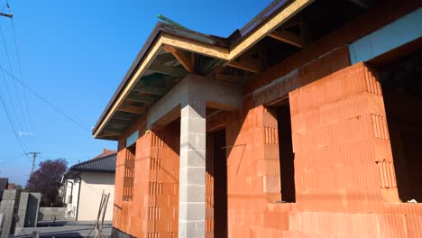 exterior view of house with exposed brick walls and wooden roof structure in sun
