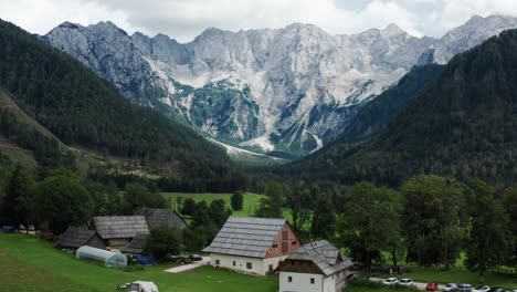 Aerial-view-of-Alpine-Valley-with-rustic-farm-in-front,-Jezersko,-Slovenia,-European-Alps,-scenic-mountain-landscape