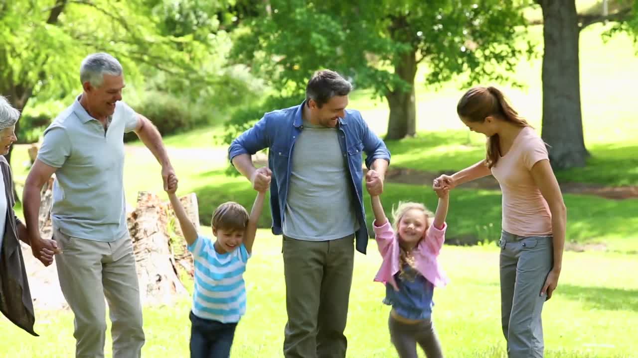 familia extendida de pie en el parque juntos posando