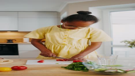 young girl chopping vegetables in a kitchen