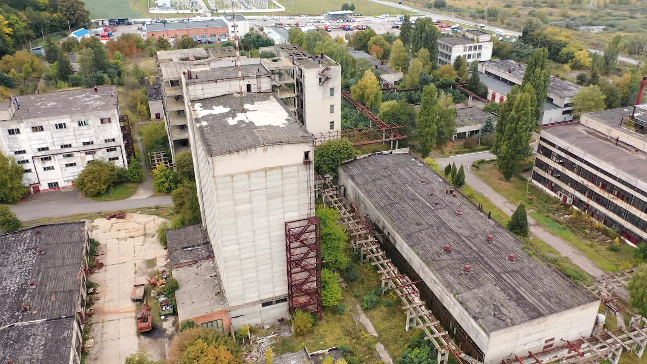 Empty factory caused by the world crisis. Abandoned buildings of industrial plant. Old brick buildings and warehouses. Camera rising.