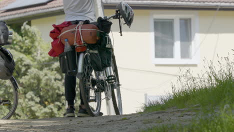 Cyclist-Standing-Beside-Touring-Cycle-With-Pannier-Bags-Attached-On-Rear-Wheel