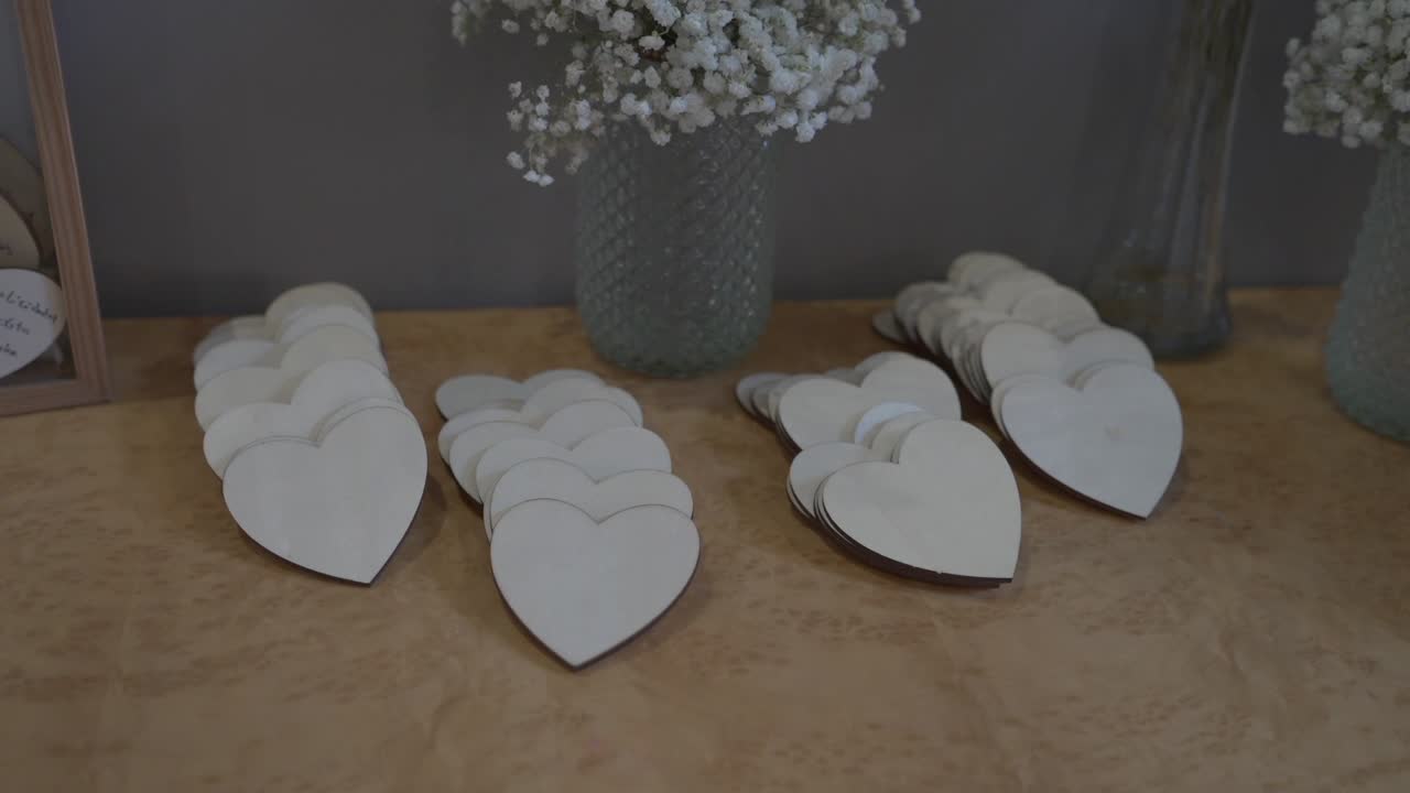 collection of small wooden heart-shaped pieces arranged neatly on a table with decorative vases
