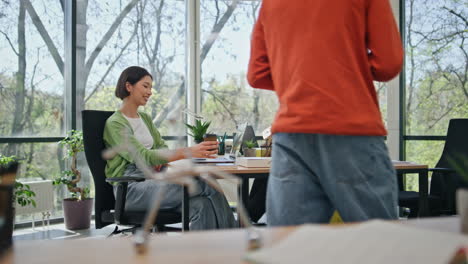 office workers sitting boardroom working together. young man bringing coffee