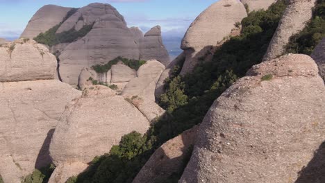 Drone-flying-between-rocks-of-Montserrat-massif-in-Catalonia,-Spain