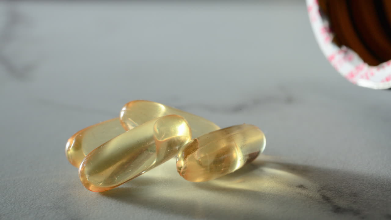 Close up of fish oil supplements scattered on a white table