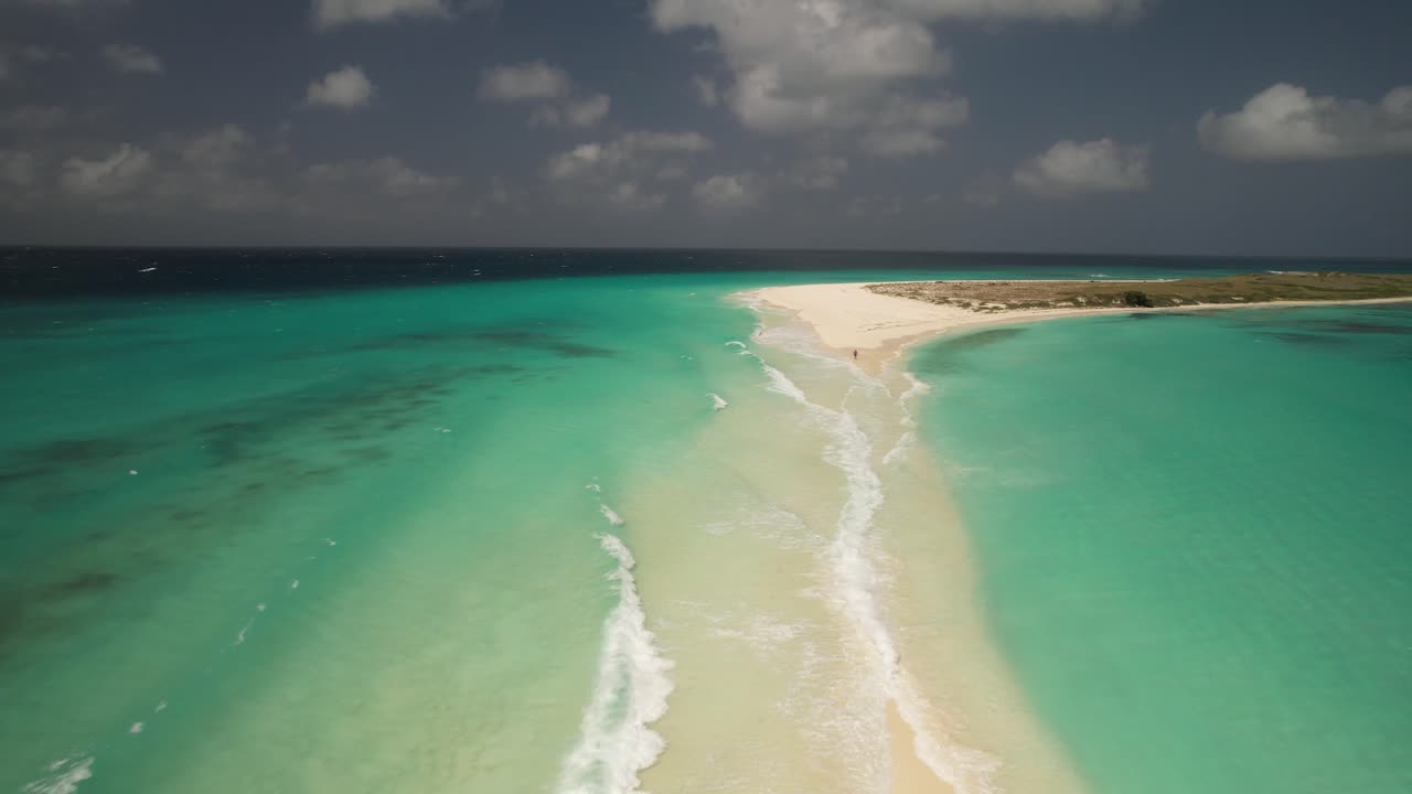 Vista aerea che si allontana da un sentiero sabbioso nelle acque cristalline di Los Roques.