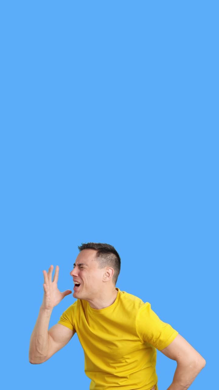 Man in yellow shirt looking up with frustrated expressions