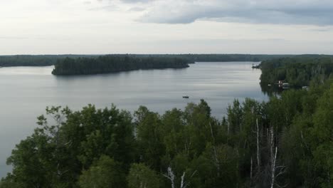 aerial, small boat sailing alone on a lake in the united states, overcast day