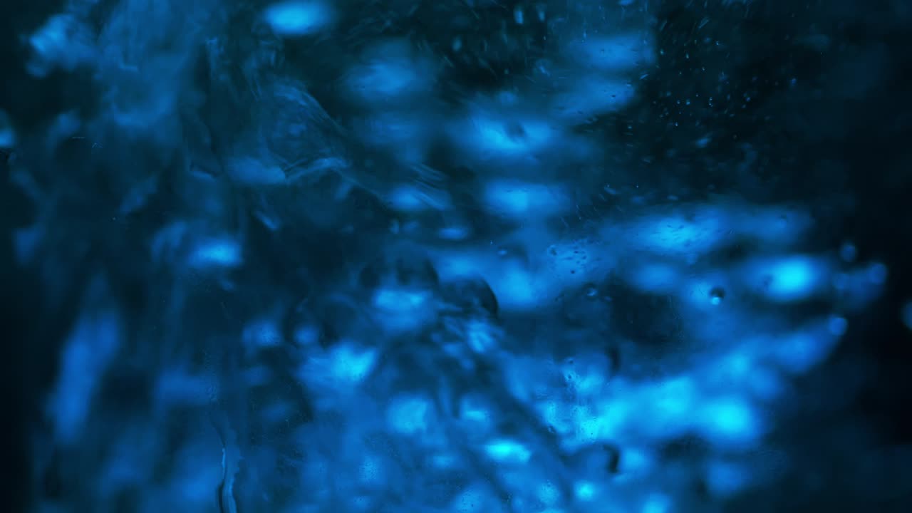 Boiling Water. Bubbles rising up on surface in blue-teal environment . Close Up.