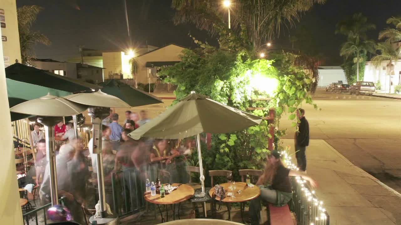 밤에 레스토랑 밖에서 후원자의 저속 촬영